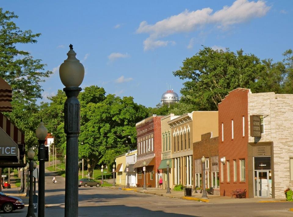 Downtown Colfax, Iowa, with brick storefronts along Main Street and the Colfax water tower